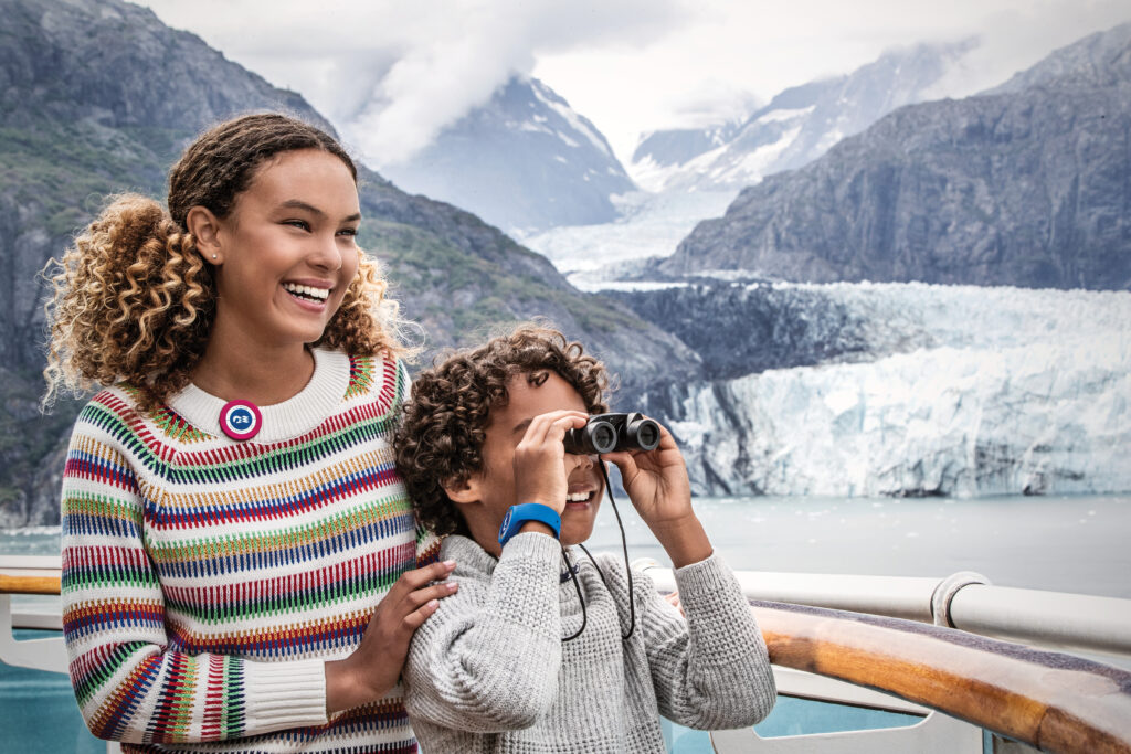 Children on a cruise ship observing glaciers with binoculars.