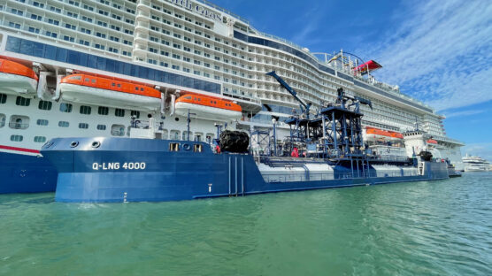 Q-LNG 4000 refuels the Mardi Gras cruise ship with LNG, showcasing sustainable maritime practices under clear skies.